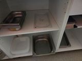 two trays and a pan on a shelf in the kitchen