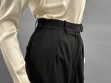 a close up of a person wearing a white shirt and black pants