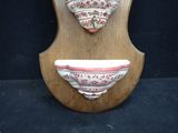 a wooden plaque with a bowl and a bowl on it