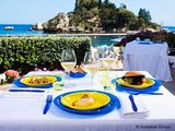 two plates of food and glasses of wine on the table
