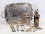a silver tray with silverware and silver spoons on it