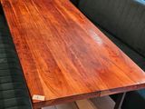 a wooden table with a bench in the corner of the room