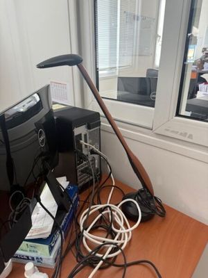 a desk with a computer and a bunch of wires on it