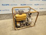 a small pump sitting on the ground in front of a wall