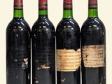 three bottles of red wine are lined up in a row