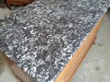 a table with a marble top sitting in the middle of a room