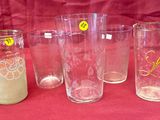 four glasses with yellow stickers are lined up on a red cloth