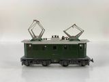 a green train car that is sitting on a white surface