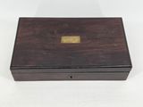 an antique wooden box with a brass plate on the lid