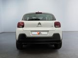 the rear end of a white citrole parked in a white room