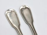 pair of silver spoons with heart shaped handles on a white surface