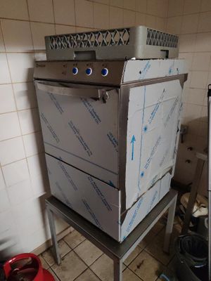 des boîtes empilées sur une cuisinière dans une cuisine où se trouve une poubelle