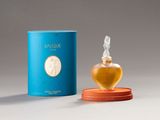 an image of a bottle of perfume sitting on top of a table