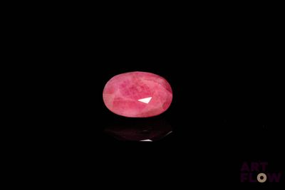 un gros plan d'une pierre rose sur une surface noire