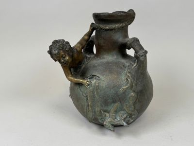 une statue en bronze représentant un garçon tenant un vase