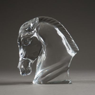 un gros plan sur une tête de cheval en verre posée sur une table