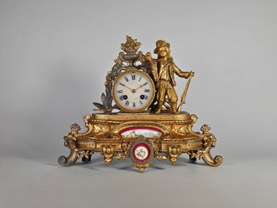 une horloge en or surmontée d'une statue