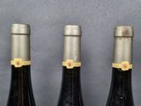 three bottles of wine are lined up on a table