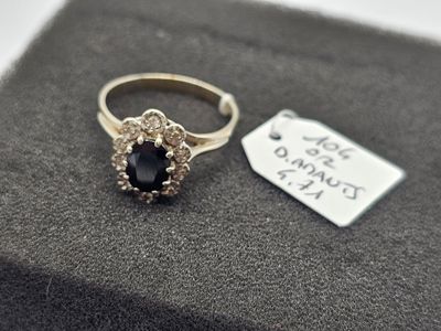 une bague ornée d'une pierre noire et d'une petite plaque