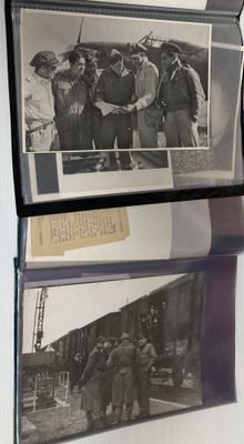 deux vieilles photos d'hommes debout sur une étagère, à côté d'une horloge
