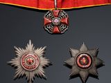 three medals and a star on a red ribbon on a black background