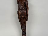 une statue en bois d'une femme avec un chapeau sur la tête