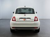 the back end of a white car in a room with a white wall