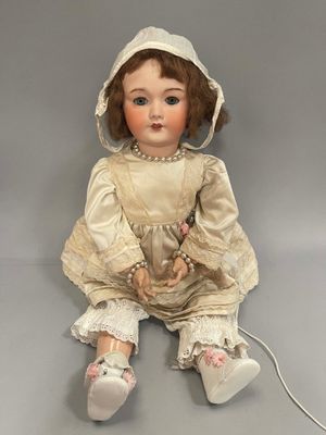 an antique doll sitting on the floor with a hat on