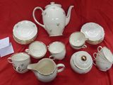 a lot of white and gold china on a red table cloth