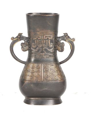 un vase en métal muni d'une anse ornée d'un motif
