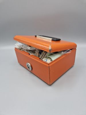 une petite boîte orange contenant de l'argent