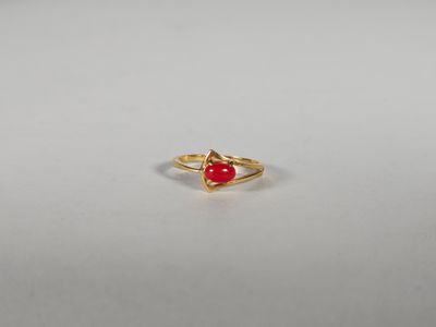 une bague en or avec une pierre rouge au centre