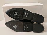 they are two pairs of black shoes sitting on top of a white box