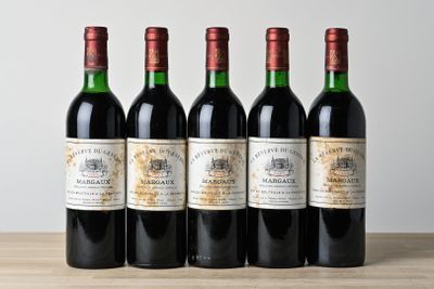 quatre bouteilles de vin sont alignées sur une table en bois