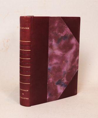 un vieux livre à la couverture rouge posé sur une surface blanche
