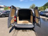 the back of a silver van with its doors open in a parking lot
