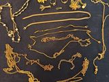 a lot of gold necklaces and bracelets on a table