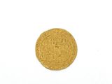 gros plan d'une pièce d'or sur une surface blanche