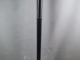 un lampadaire noir surmonté d'un abat-jour en verre