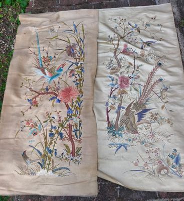 deux morceaux de tissu ornés d'oiseaux et de fleurs, posés par terre