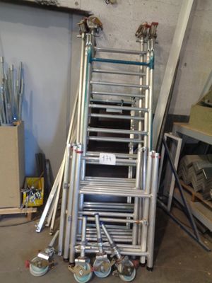 a lot of ladders that are stacked up in a room