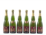 six bouteilles de vin sont alignées sur une surface blanche