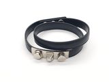 bracelet en cuir noir orné de clous argentés sur fond blanc
