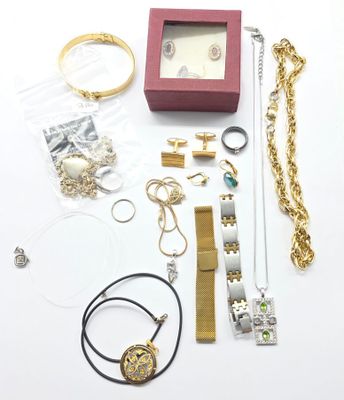 de nombreux bijoux posés sur une table blanche, à côté d'une boîte rouge