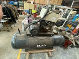 un petit compresseur d'air posé sur une palette dans un garage