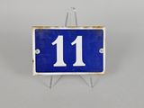 une photo d'une plaque de numéro de maison bleue et blanche fixée sur un support métallique
