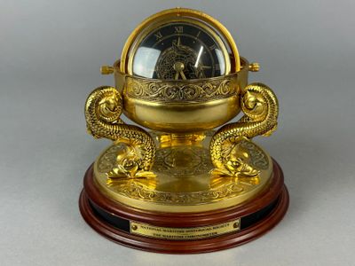 une horloge en or posée sur un socle en bois orné d'un dragon