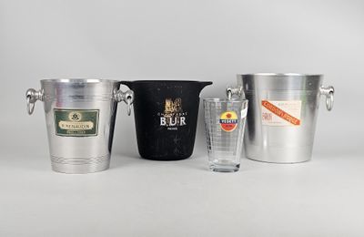 trois seaux en métal et un verre sont posés sur une table