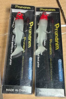 une paire de tubes de dentifrice en forme de poisson, dans leur emballage en plastique, posés sur une table