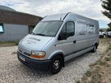 a silver van that is parked in a gravel lot